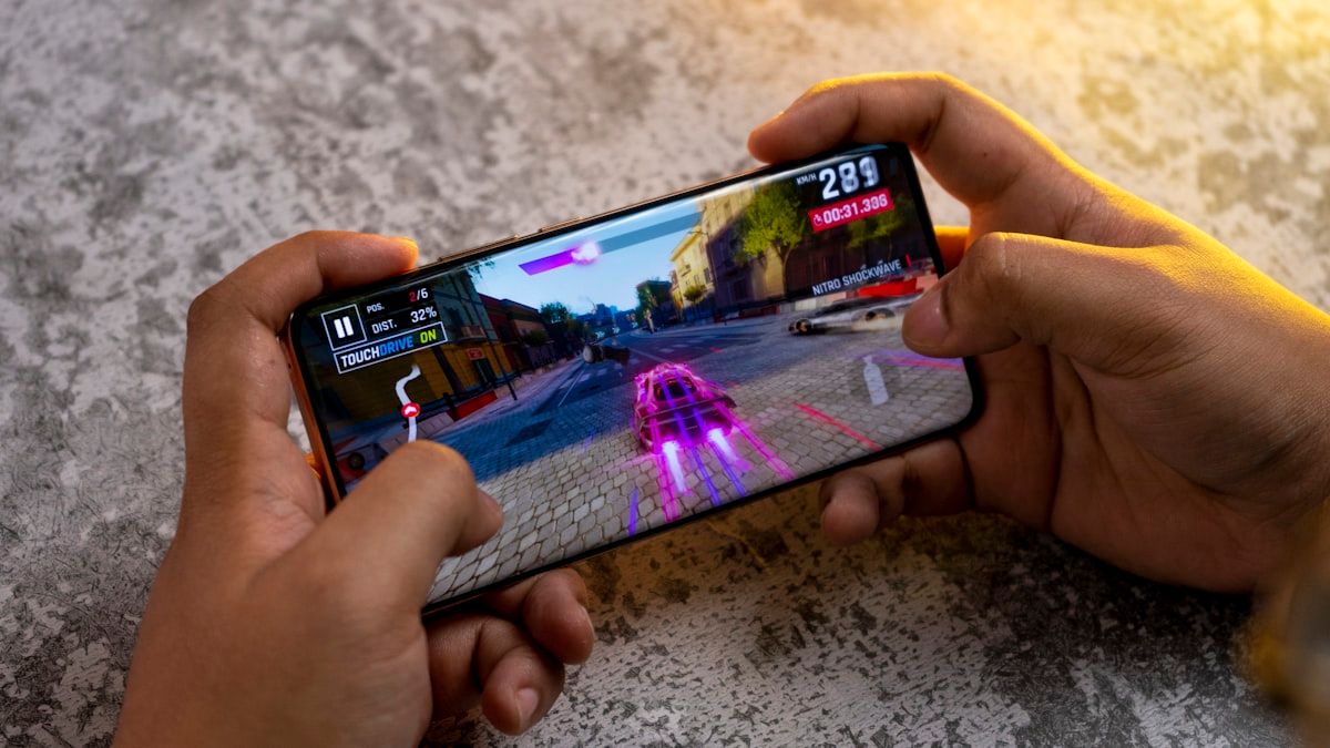 Jogo de corrida grátis no celular Pessoa jogando jogo de corrida no celular com carro em alta velocidade na tela